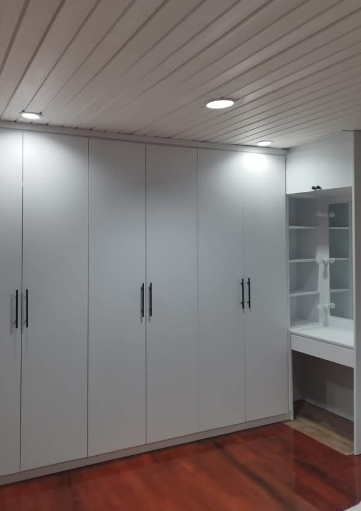 Closet moderno con acabados en MDF blanco y detalles en madera cálida.